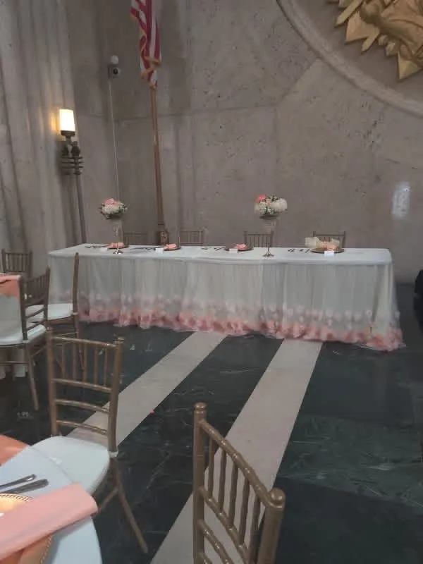 Romantic floral banquet table with pink linens, gold vessels, and silk floral arrangements