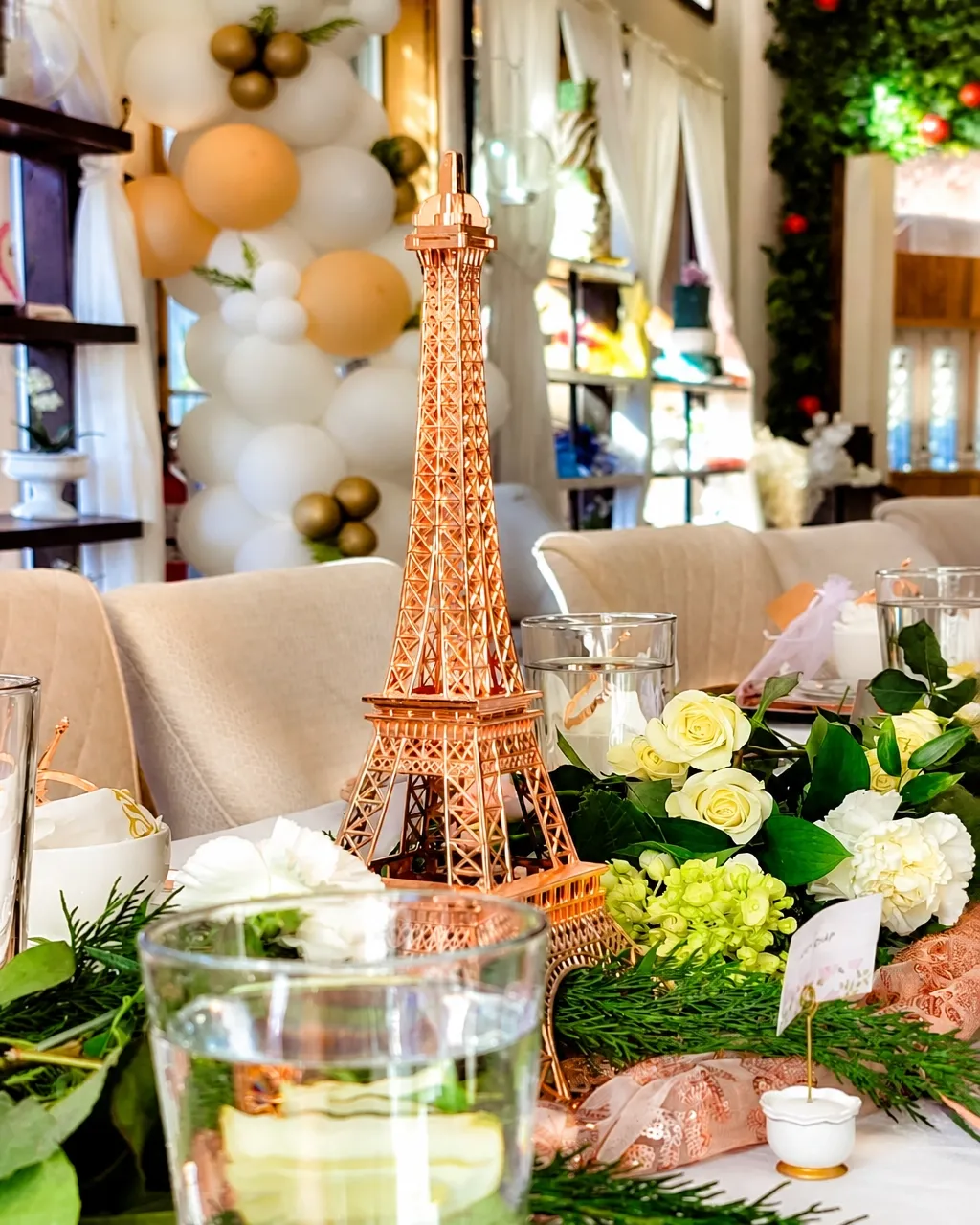 Parisian rose-gold tablescape with an Eiffel Tower centerpiece, florals, and place settings